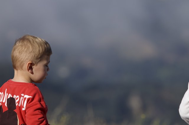 Young Boy Gazes Thoughtfully Against Stormy Mountain Sky