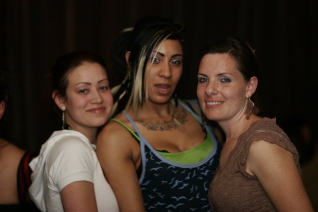 Three Friends Posing Together at Nightclub Event