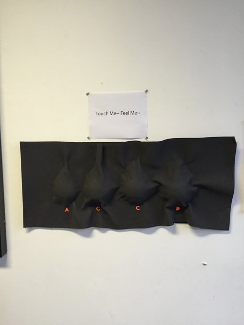 Three Black Pieces of Fabric on Black Wall