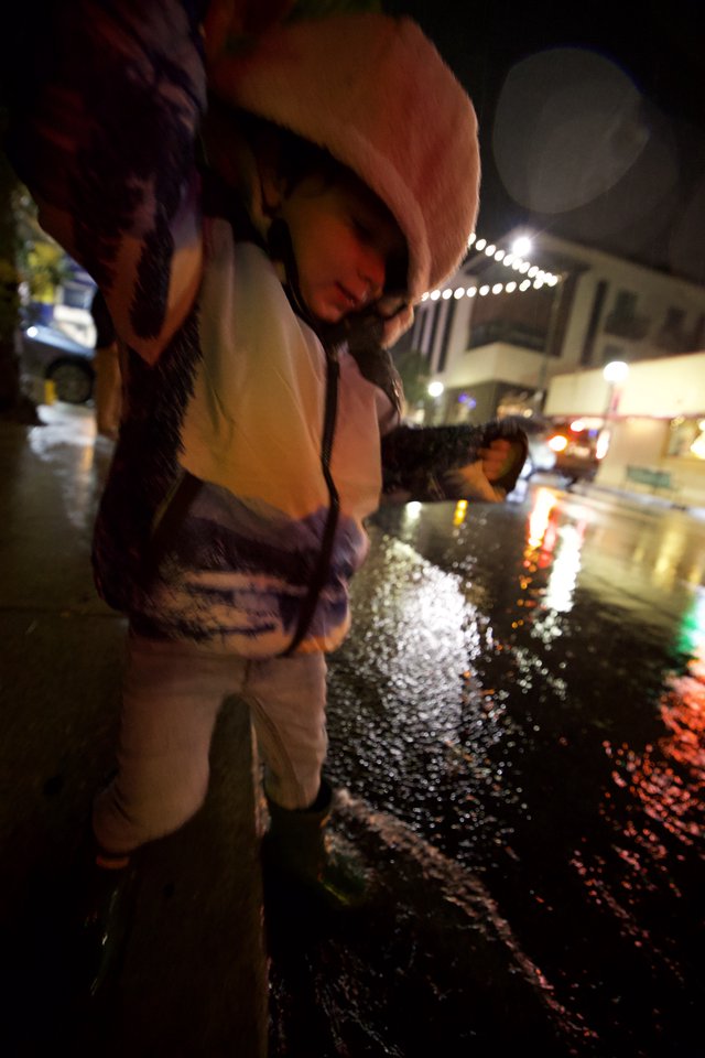 Child Explores Ice Installation at Nighttime Downtown Event