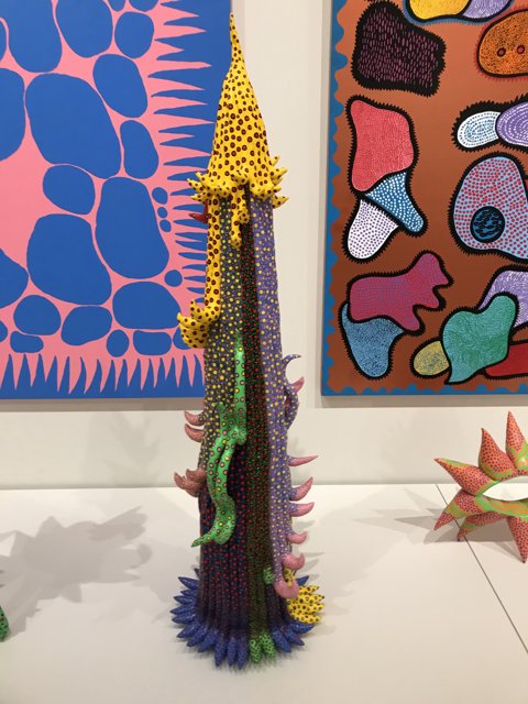 Artistic Fusion: A Vibrant Sculpture Complements a Striking Painting