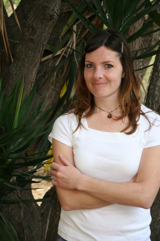 Woman Smiling Beside Tropical Tree Outdoors