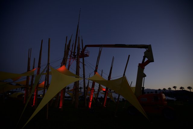 Crane lifts massive tent into the night sky