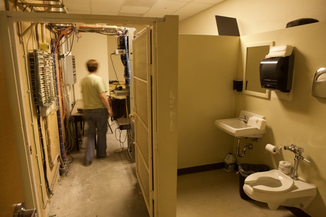 A Man Walks Through a Clinic Bathroom
