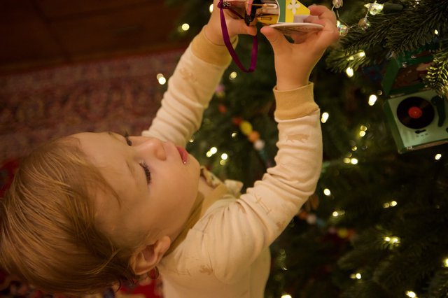 Child Decorating Christmas Tree with Ornament