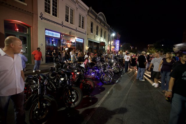 Motorcycle enthusiasts gather under the night sky