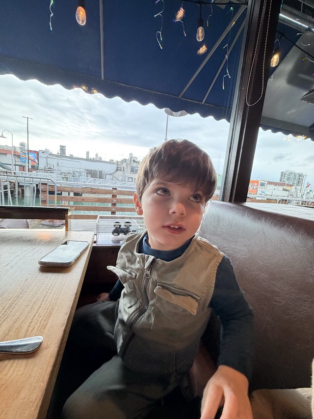 Young Boy at Rooftop Restaurant with City Views