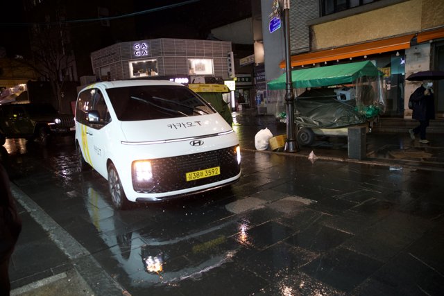 Rainy Night in Korea: White Van on a Wet Street