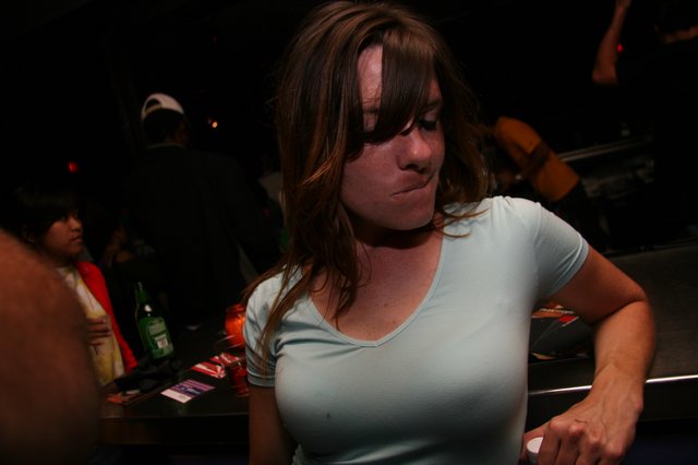 Young Woman at Crowded Nightclub Bar Scene