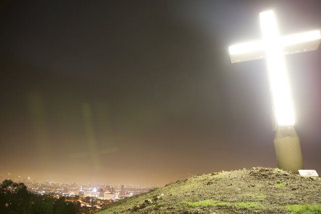 Cross on Hill with Cityscape