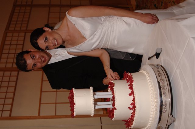 Bride and Groom Cut Three-Tier Wedding Cake Together