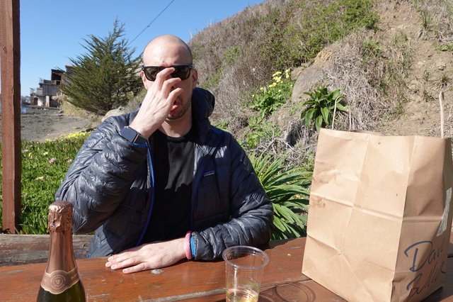 Man Enjoying Outdoor Meal with Champagne
