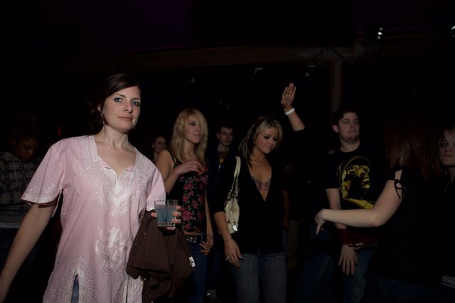 Young Woman at Nightclub Glances at Camera