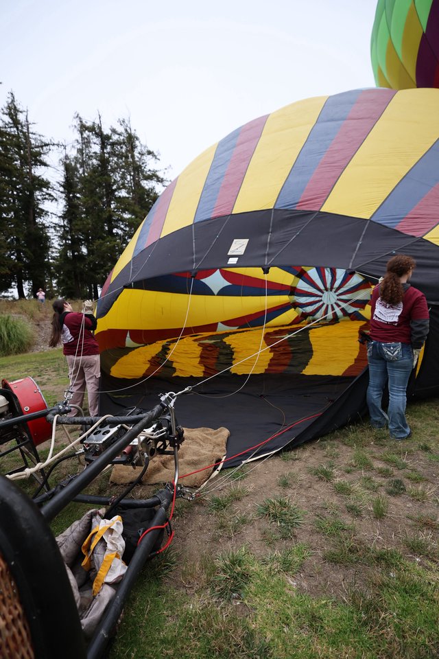 Volunteers Inflate Colorful Hot Air Balloon at Festival