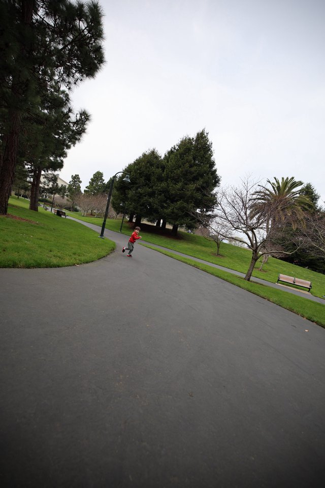 Child Running on Winding Park Path on Overcast Day