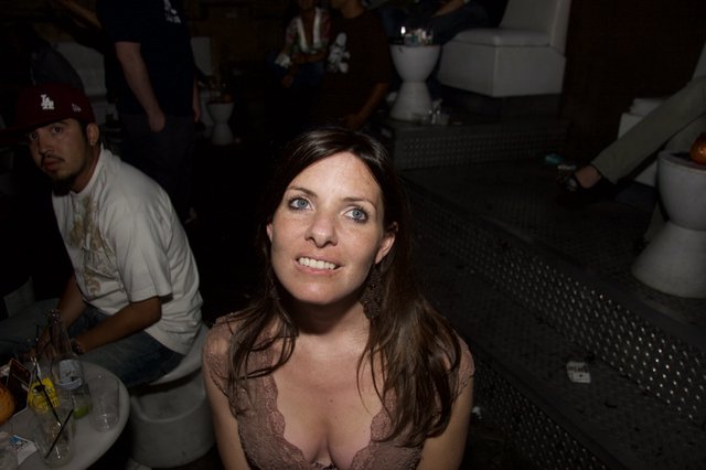 Woman Smiling Up at Camera in Nightclub Setting