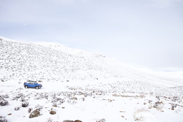 Blue Car on Snowy Slope