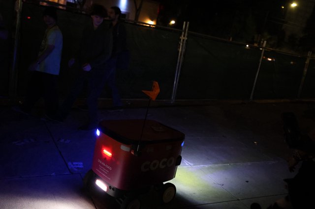 Coco Delivery Robot Navigates Sidewalk at Night Festival