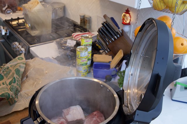 Pressure Cooker with Raw Meat on Cluttered Kitchen Counter