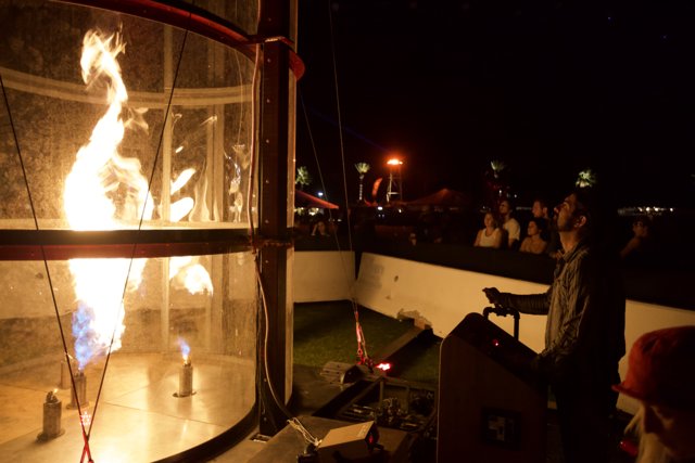Man Standing in Glass Box Amidst Fire