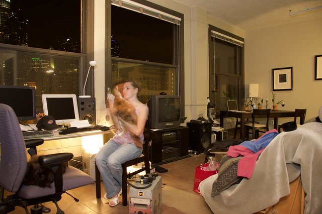 Woman Cuddles Cat in Urban Loft Apartment at Night