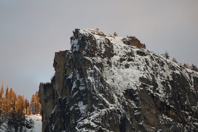 Snow-Covered Rock Pinnacle in Winter Mountain Forest