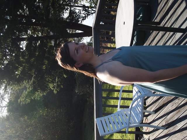 Joyful Woman Relaxing on Sunlit Outdoor Deck