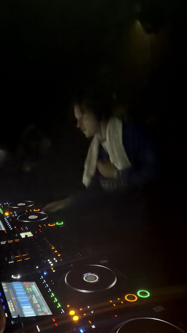DJ at Work Behind Illuminated CDJ Decks in London