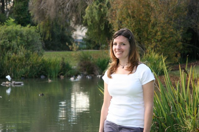 Smiling Woman by a Tranquil Park Pond