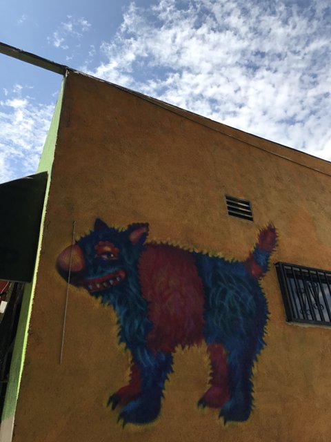 Colorful Mural of a Dog on a Yellow Building