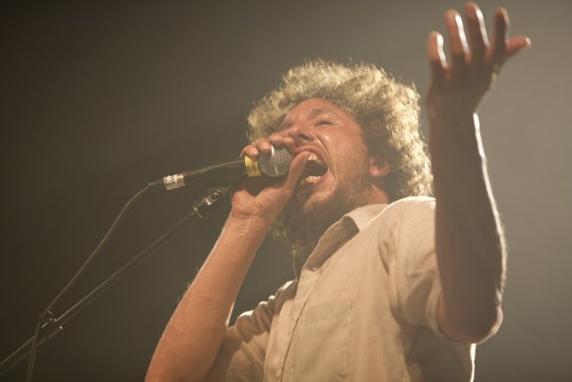 Solo Performance: Man with Curly Hair Singing into a Microphone