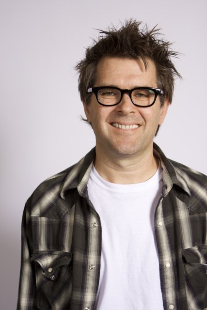 Smiling Man in Plaid Shirt and Glasses