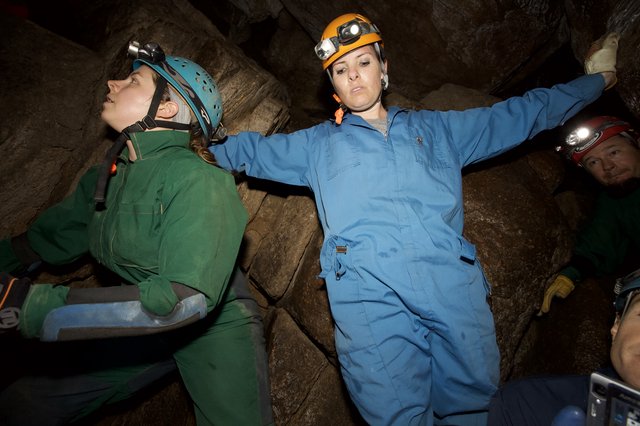 Cavers Navigate Tight Underground Passage in Cave
