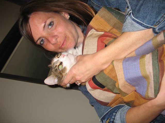 Woman Cuddling Tabby Kitten with Affectionate Smile