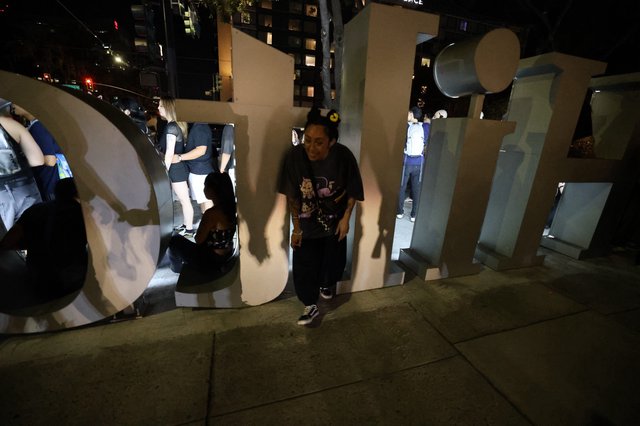 Night Revelers Pose Among Giant Festival Letters