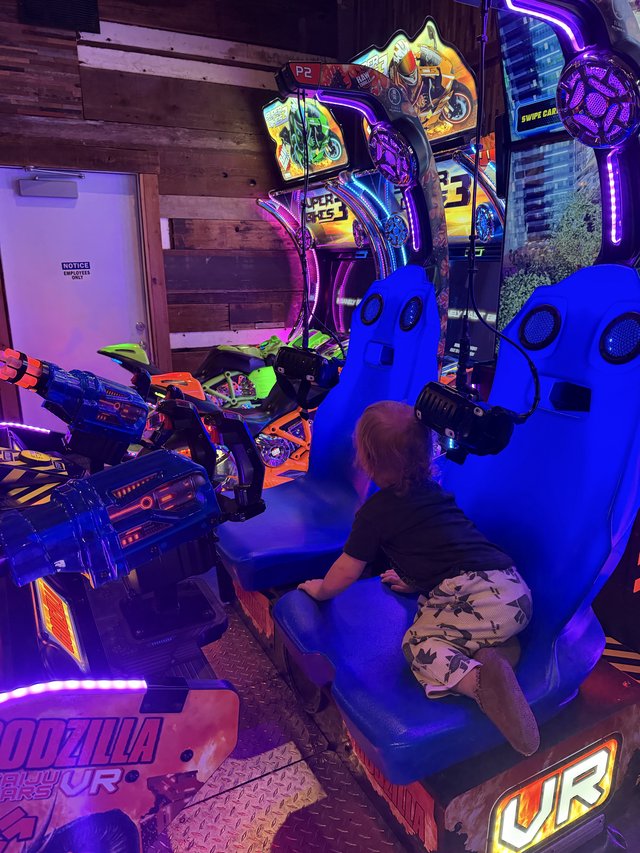 Gamer Playing Virtual Reality Motorcycle Arcade Game