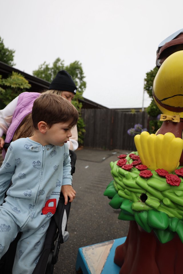 Curious Child Examines Colorful Festival Statue Up Close