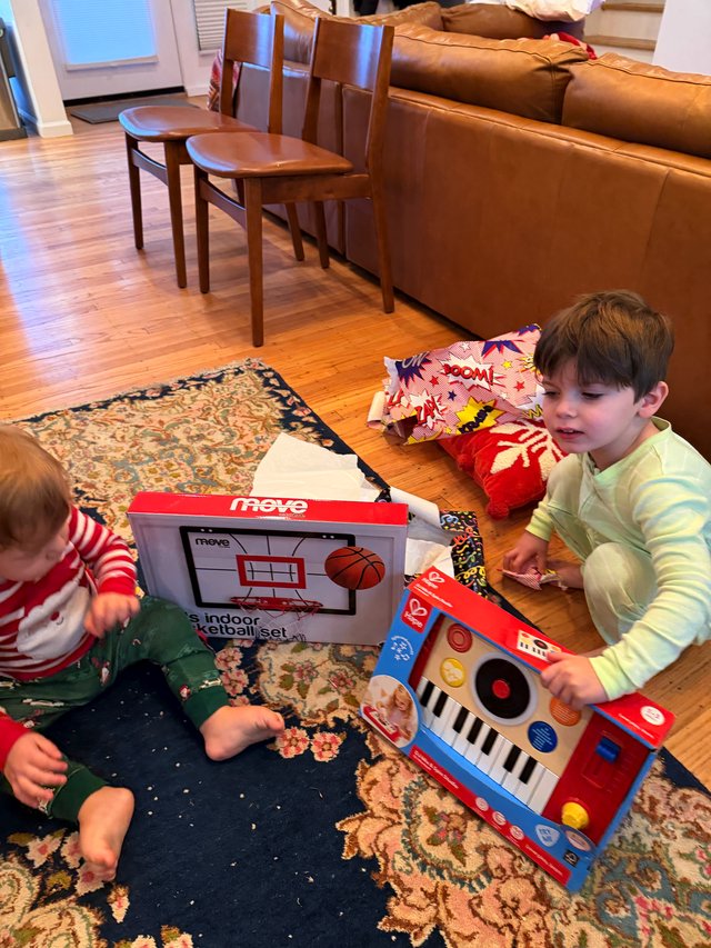 Children Opening Christmas Gifts in Cozy Living Room