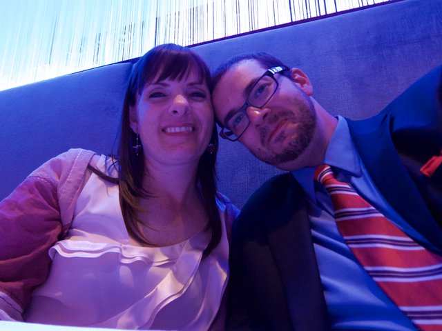 Couple Poses Together in Blue-Lit Lounge