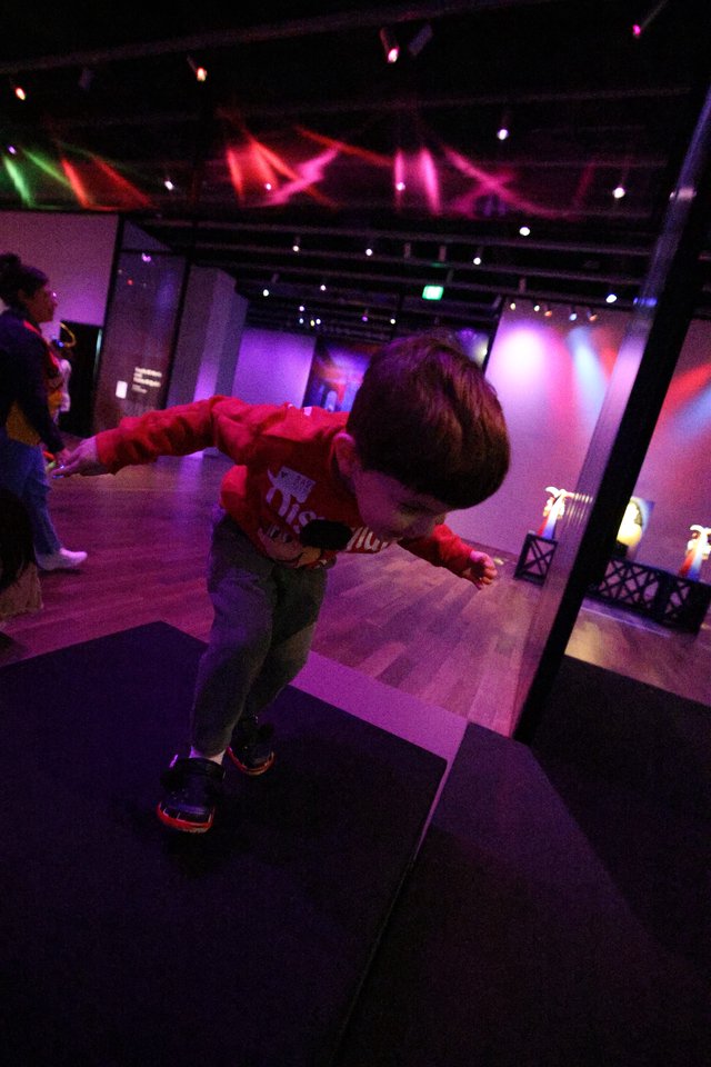 Child Dancing at Baby Rave Event Under Colorful Lights