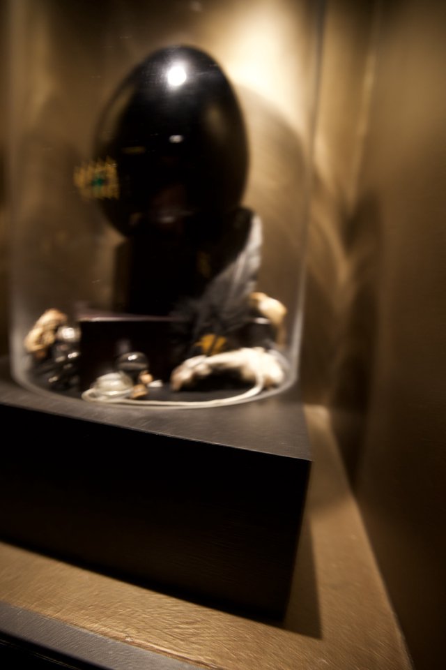 Dark Sculptural Mask Display in Glass Case