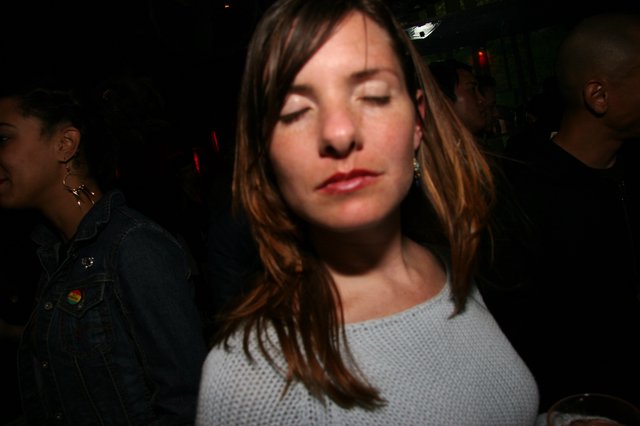 Woman Eyes Closed in Dimly Lit Nightclub