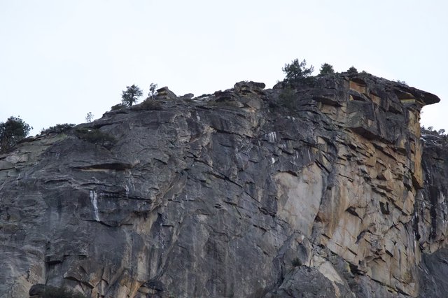 Dramatic Layered Rock Face with Overhanging Cliff Edge