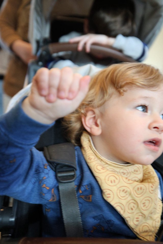 Young Child Waving from Car Seat During Road Trip