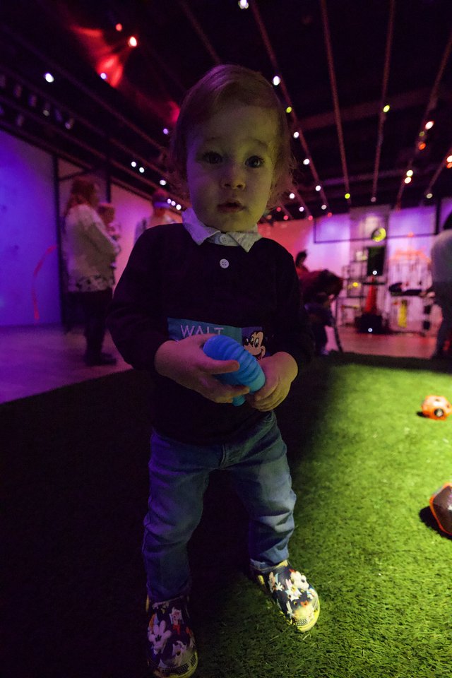 Toddler at Baby Rave Event Under Colorful Lights