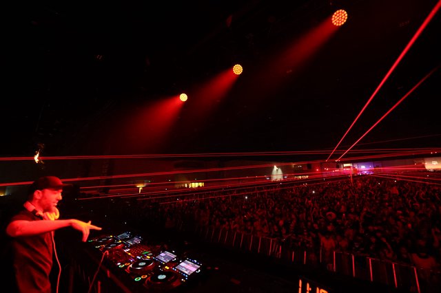 DJ Commands Massive Crowd Under Red Laser Storm