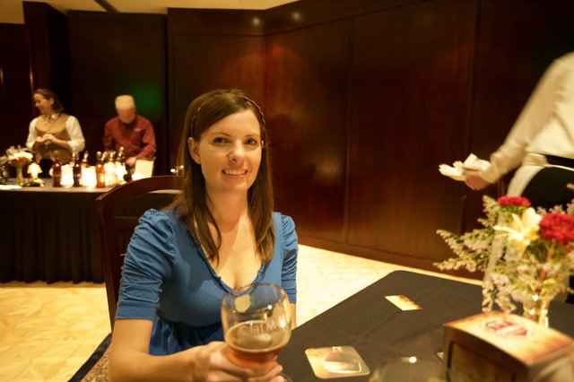 Penelope Smiling with Chimay Beer at Elegant Event