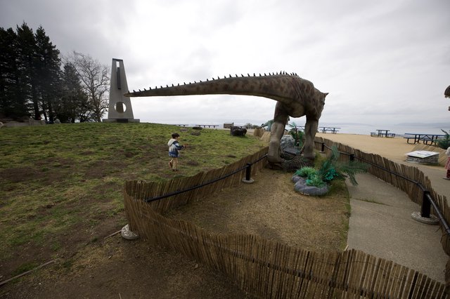 Child Encounters Life-Size Dinosaur Statue at Coastal Park
