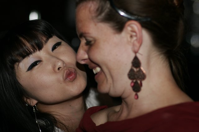 Two Friends Share a Playful Cheek Kiss Moment