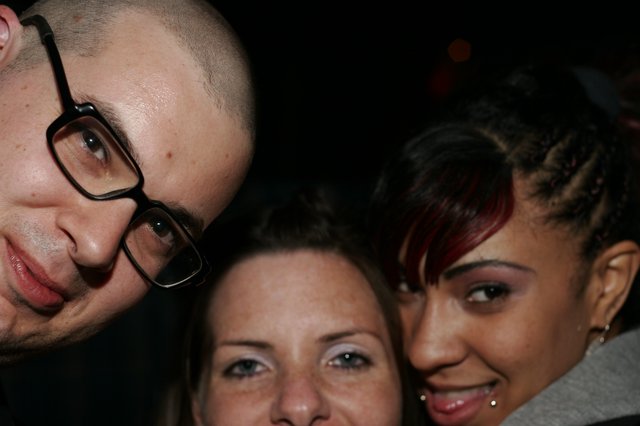 Three Friends Posing Together at a Nighttime Event